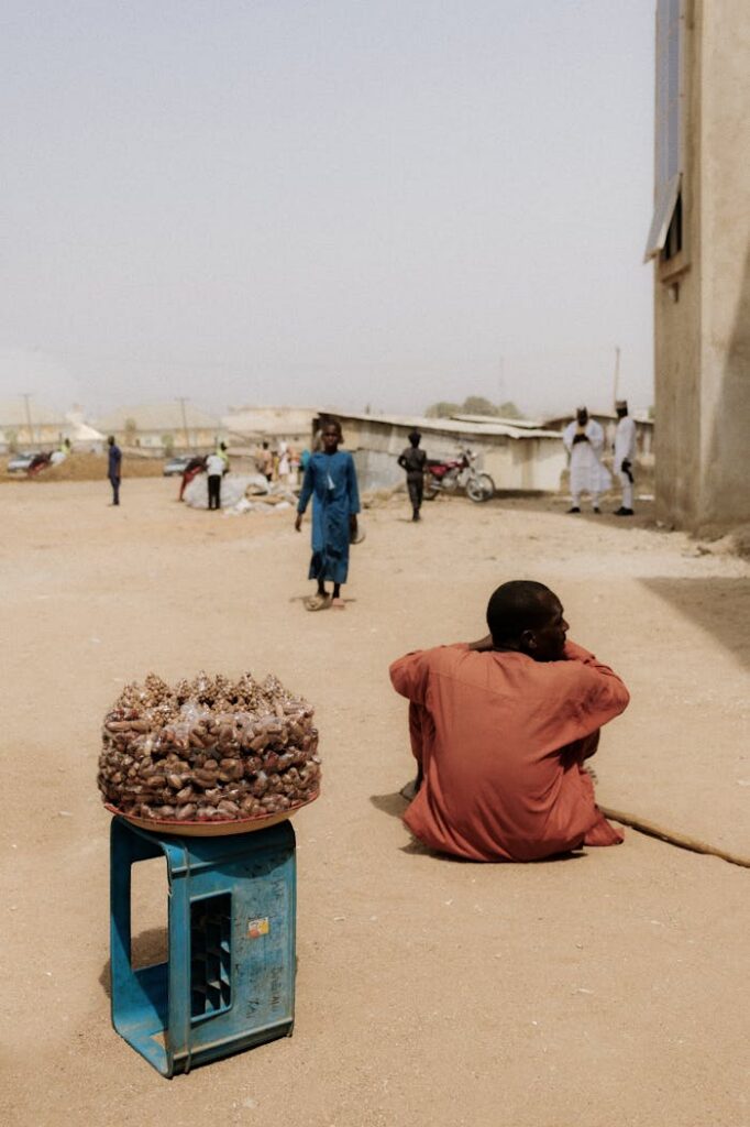 A candid moment capturing street life in Suleja, Nigeria, with people and local vendor.